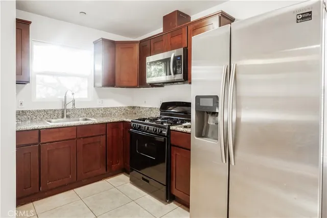 a kitchen with stainless steel appliances granite countertop a refrigerator and a sink