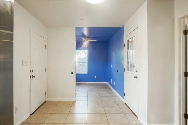 a view of a hallway with a chandelier fan and door