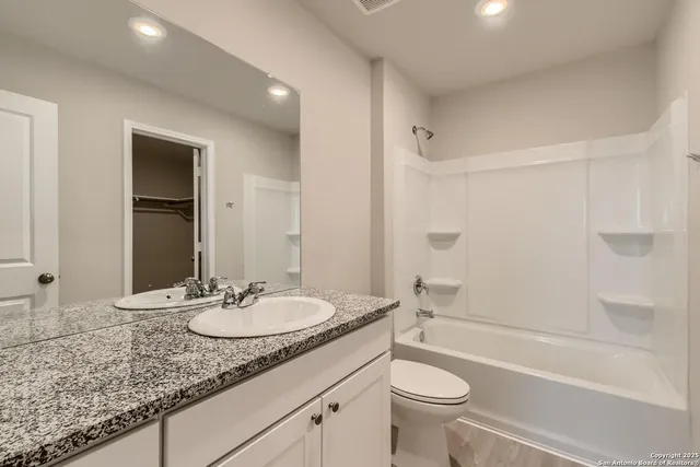 a bathroom with a granite countertop sink toilet and shower