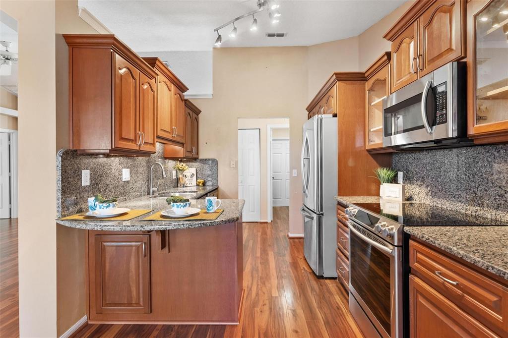 11614 Southeast 172nd Loop Summerfield, FL 34491 - Photo 13 of 55 a kitchen with kitchen island granite countertop a sink stove and refrigerator