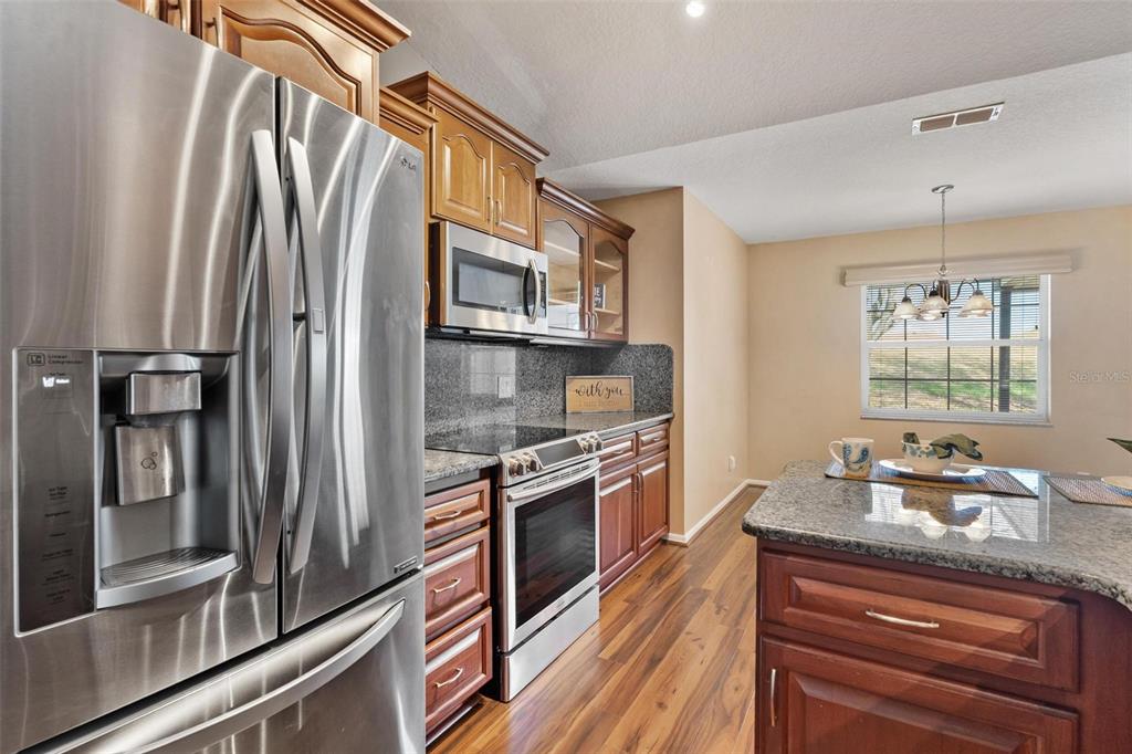11614 Southeast 172nd Loop Summerfield, FL 34491 - Photo 14 of 55 a kitchen with stainless steel appliances granite countertop a refrigerator and a stove