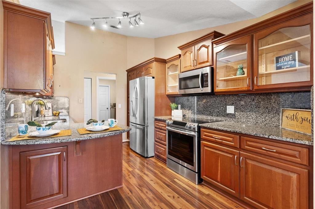 11614 Southeast 172nd Loop Summerfield, FL 34491 - Photo 5 of 55 a kitchen with stainless steel appliances granite countertop a sink stove and refrigerator