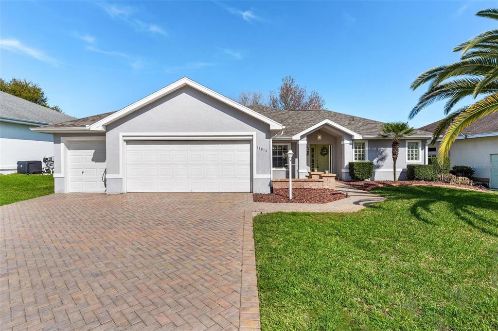 11614 Southeast 172nd Loop Summerfield, FL 34491 - Photo 6 of 55 a view of a white house next to a yard with palm trees