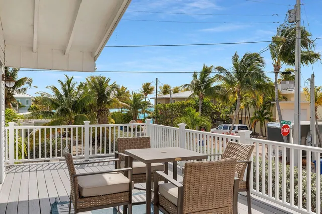 a view of a roof deck with table and chairs with wooden floor