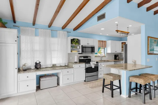 a kitchen with stainless steel appliances kitchen island granite countertop a refrigerator and a stove top oven