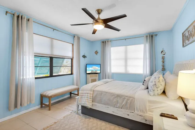 a bedroom with a large bed a chandelier and a window