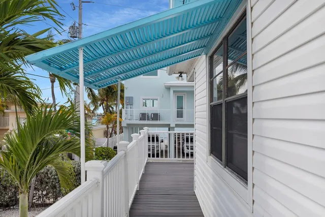 a side view of a house with a yard and potted plants