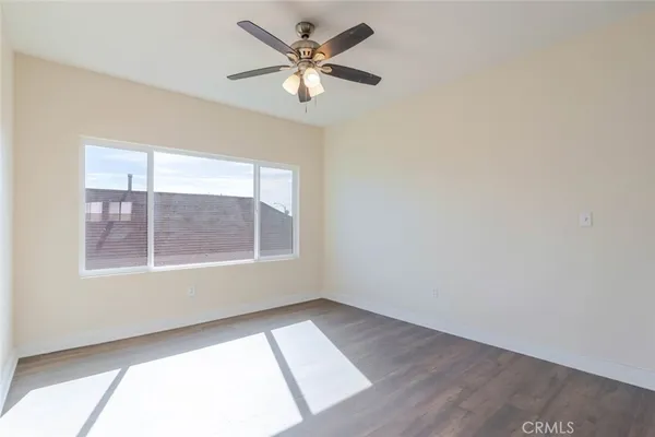 an empty room with a window and a fan