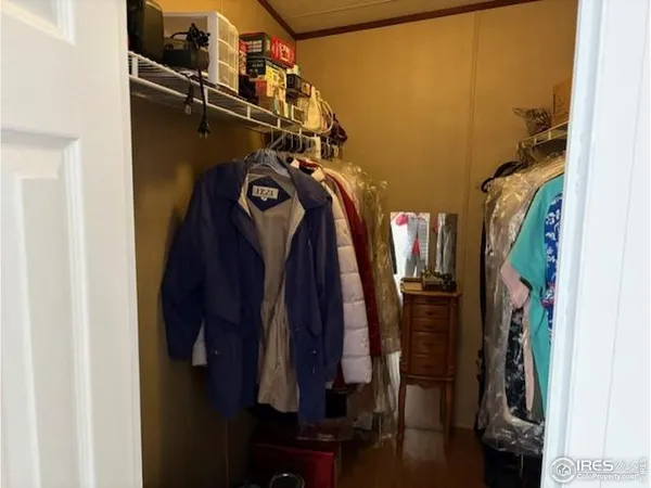 a view of walk in closet with clothes and shoes