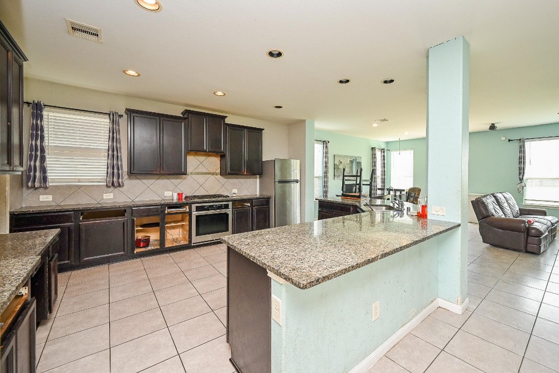 7007 Flewellen Falls Lane Spring, TX 77379 - Photo 5 of 20 a kitchen with stainless steel appliances granite countertop a sink counter space and cabinets