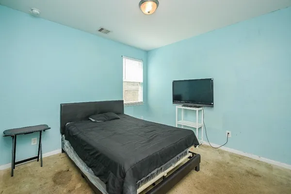 a bedroom with a bed and a flat screen tv