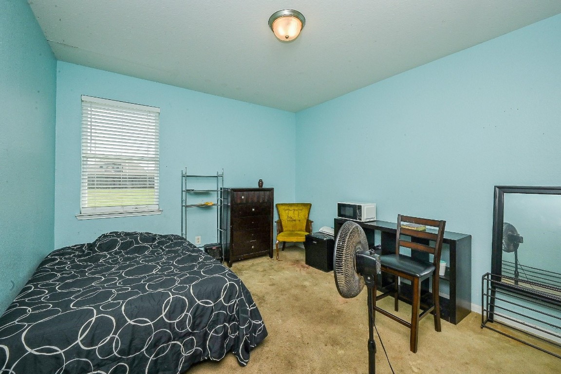 7007 Flewellen Falls Lane Spring, TX 77379 - Photo 10 of 20 a bedroom with a bed and a chandelier