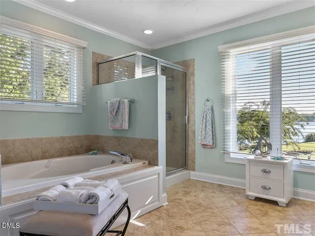 a spacious bathroom with a double vanity sink a large mirror and a bathtub next to a window