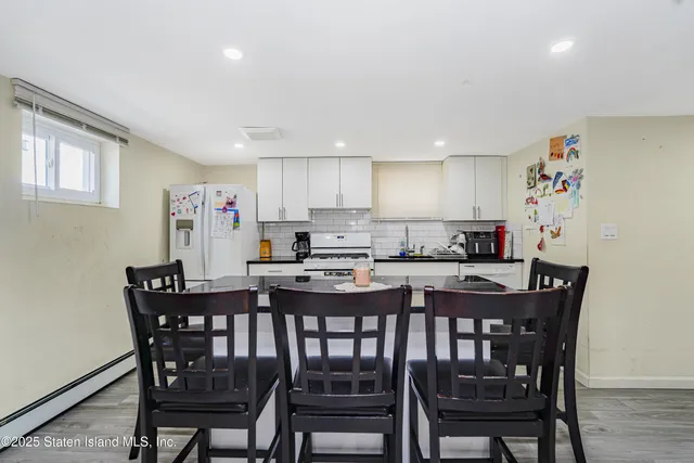 a large white kitchen with lots of counter space and refrigerator