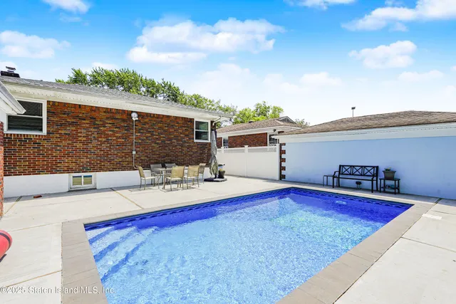 a view of house with swimming pool and sitting area