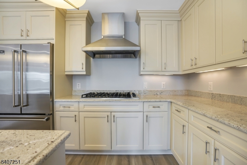 40 West Park Place, Unit 412 Morristown, NJ 07960 - Photo 4 of 32 a kitchen with white cabinets and a stainless steel refrigerator stove