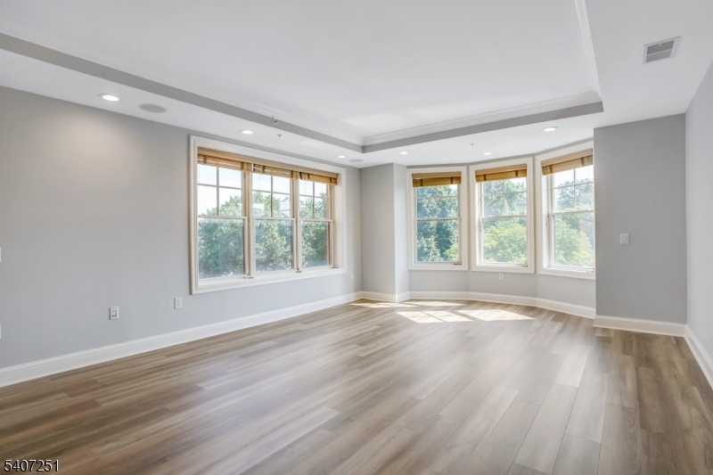 40 West Park Place, Unit 412 Morristown, NJ 07960 - Photo 7 of 32 a view of an empty room with wooden floor and a window