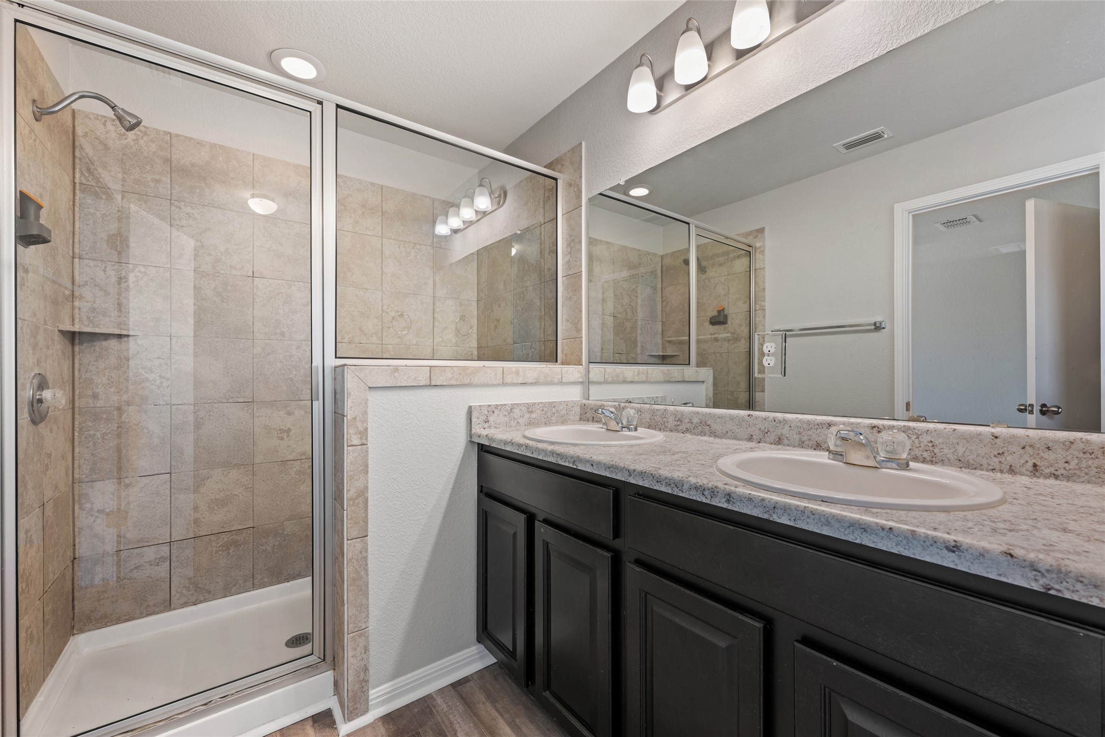 124 Guemal Road Buda, TX 78610 - Photo 32 of 40 A well-appointed primary bathroom showcases a spacious shower alongside a dual-sink vanity.