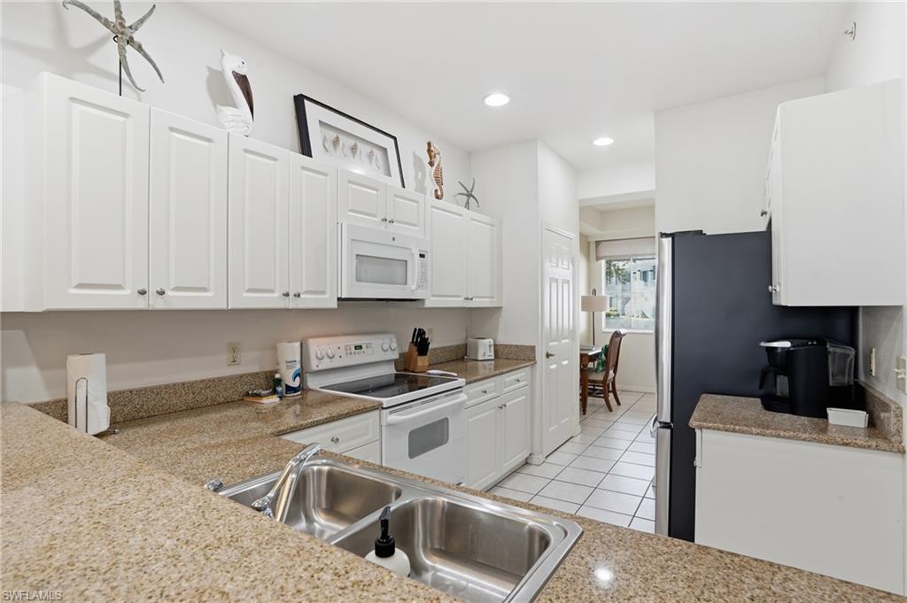 7920 Mahogany Run Lane, Unit 1015 Naples, FL 34113 - Photo 18 of 41 a kitchen that has a sink cabinets counter space and appliances