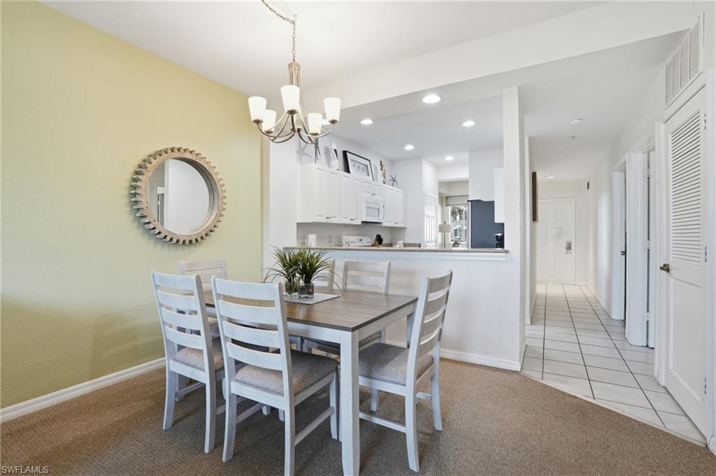 7920 Mahogany Run Lane, Unit 1015 Naples, FL 34113 - Photo 19 of 41 a dining room with furniture and a chandelier