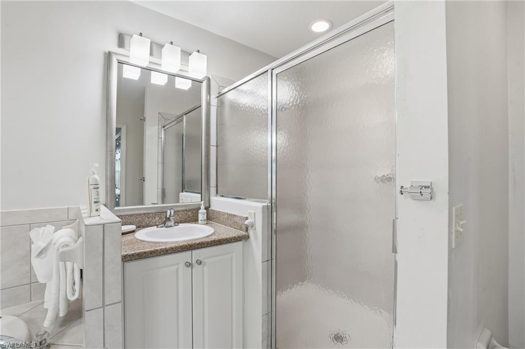 7920 Mahogany Run Lane, Unit 1015 Naples, FL 34113 - Photo 28 of 41 a bathroom with a double vanity sink mirror and shower