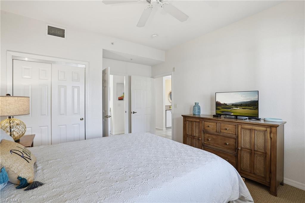 7920 Mahogany Run Lane, Unit 1015 Naples, FL 34113 - Photo 31 of 41 a bedroom with a bed and wooden floor