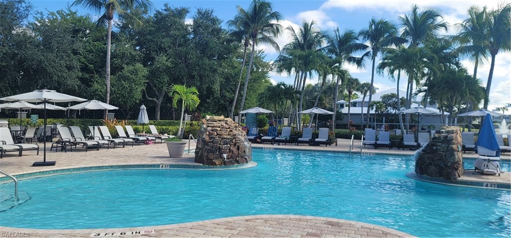7920 Mahogany Run Lane, Unit 1015 Naples, FL 34113 - Photo 6 of 41 a view of a swimming pool with a table and chairs