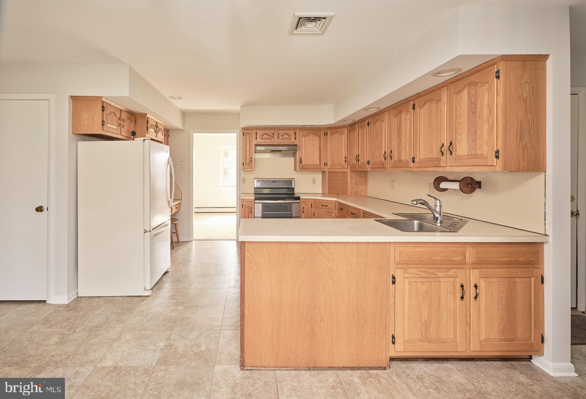 4902 Anderson Road Doylestown, PA 18902 - Photo 18 of 46 a kitchen with a sink a refrigerator and cabinets