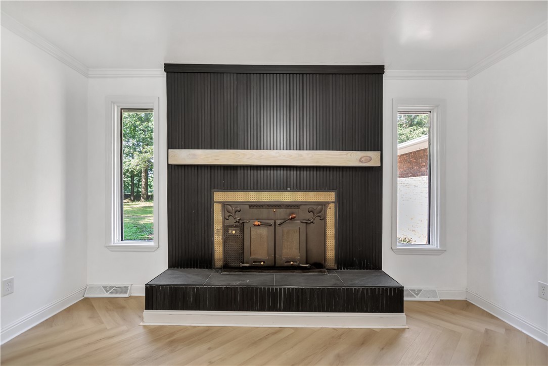 809 Paige Road Honea Path, SC 29654 - Photo 13 of 33 Fireplace featuring a black ribbed paneling surround, a light wood mantle, and a dark hearth
