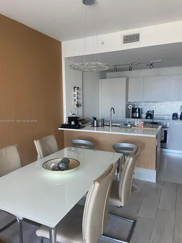 a dining room with furniture and a potted plant