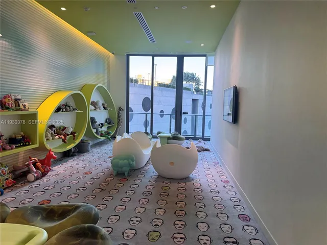 a view of a hallway to an empty room and window