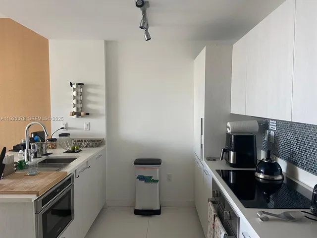 a kitchen with a sink and a stove top oven