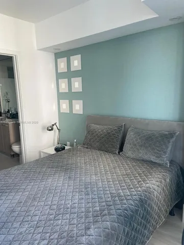 a large bed sitting in a bedroom next to a window