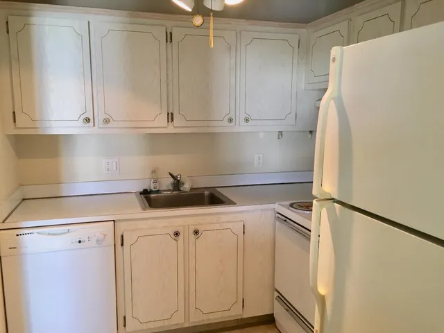a kitchen with white cabinets and white appliances