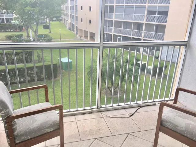 a view of a balcony with a floor to ceiling window next to a tall building