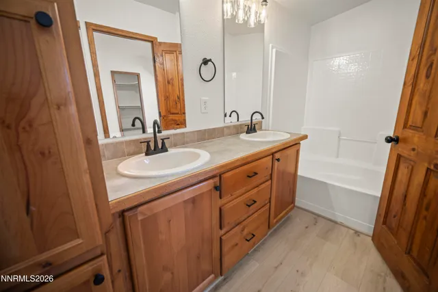 a bathroom with a granite countertop sink a mirror a vanity and a bathtub