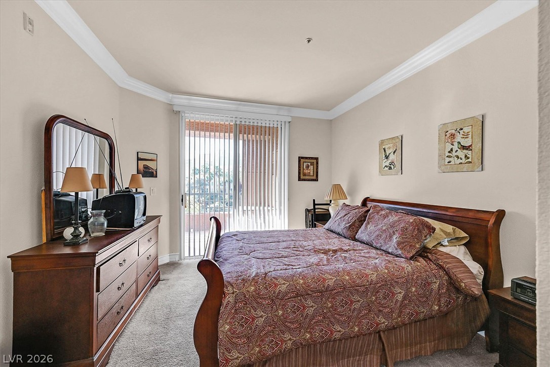 220 East Flamingo Road, Unit 305 Las Vegas, NV 89169 - Photo 8 of 26 A comfortable bedroom featuring crown molding and private balcony access for peaceful mornings.