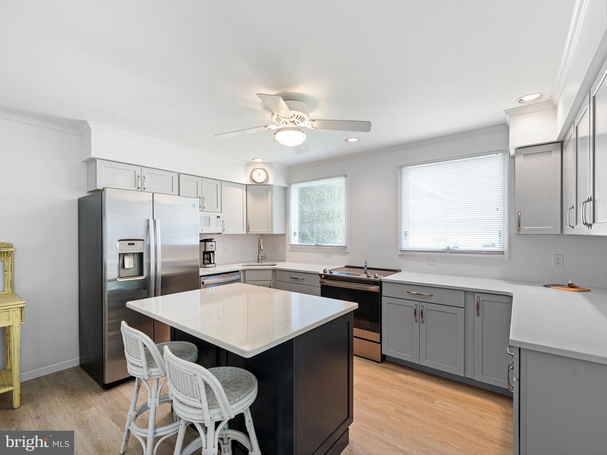 532 Bethany Loop Bethany Beach, DE 19930 - Photo 20 of 65 a kitchen with refrigerator a sink dishwasher a stove a dining table and chairs with wooden floor