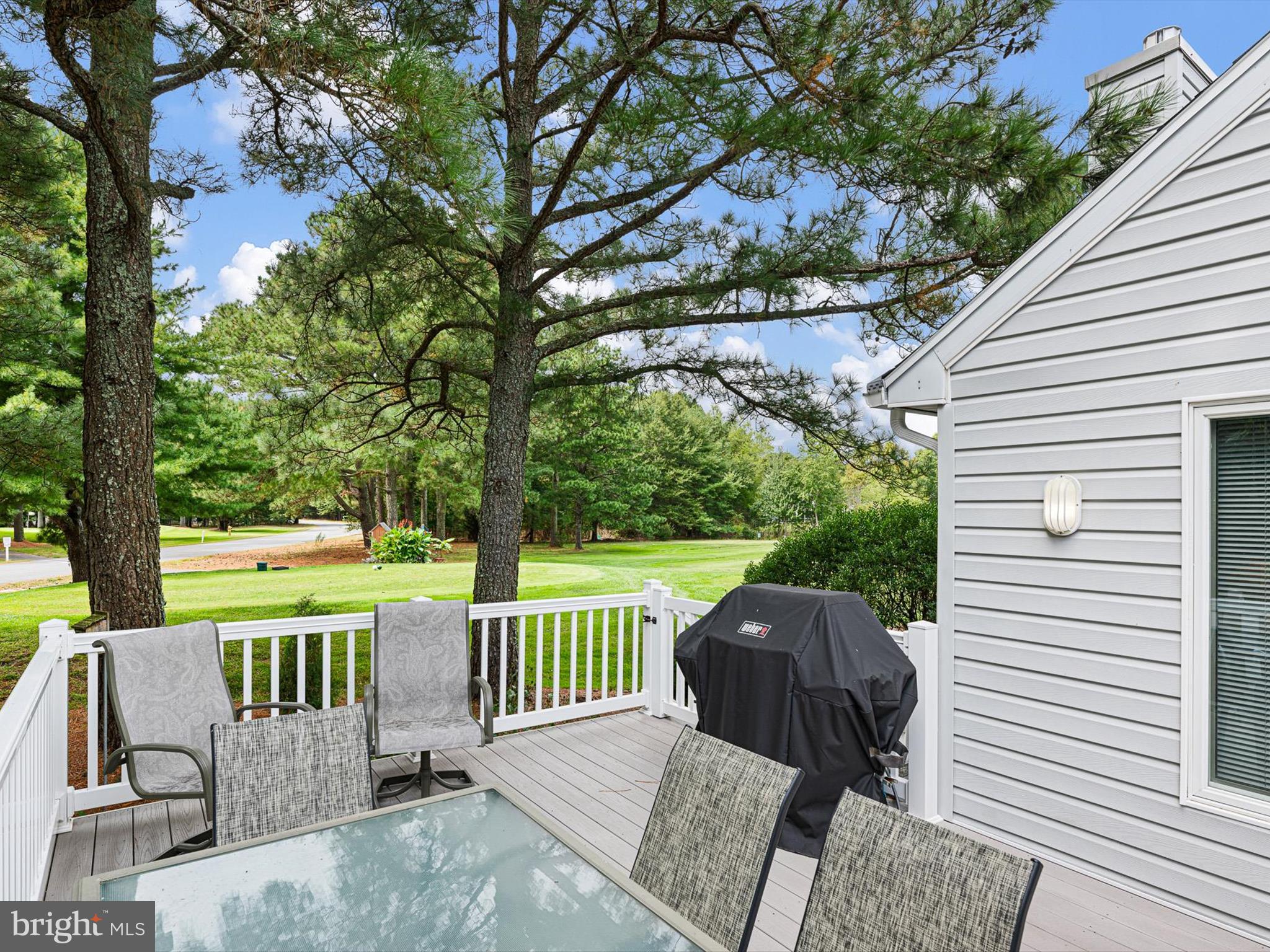 532 Bethany Loop Bethany Beach, DE 19930 - Photo 5 of 65 a view of a patio with a table chairs and a floor to ceiling window