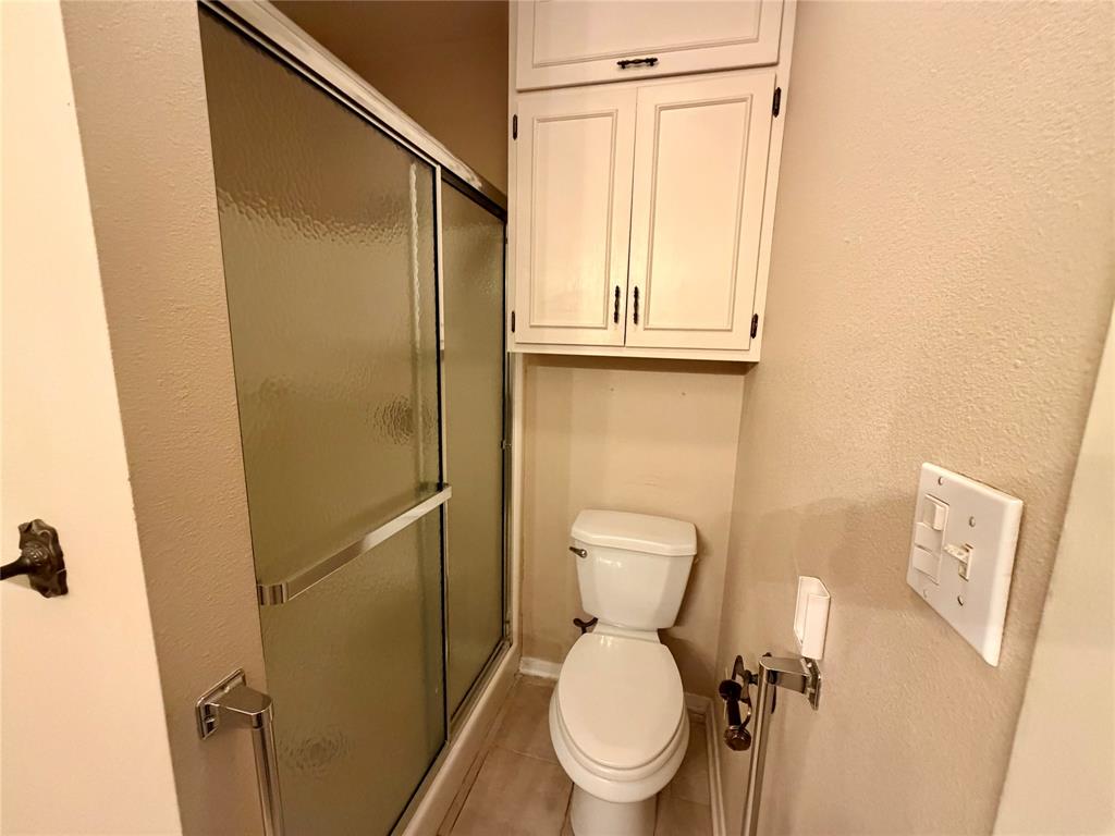 2030 Sycamore Street Paris, TX 75460 - Photo 11 of 24 Full shower enclosure with textured glass sliding doors and chrome hardware