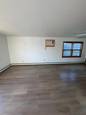a view of room with window and wooden floor