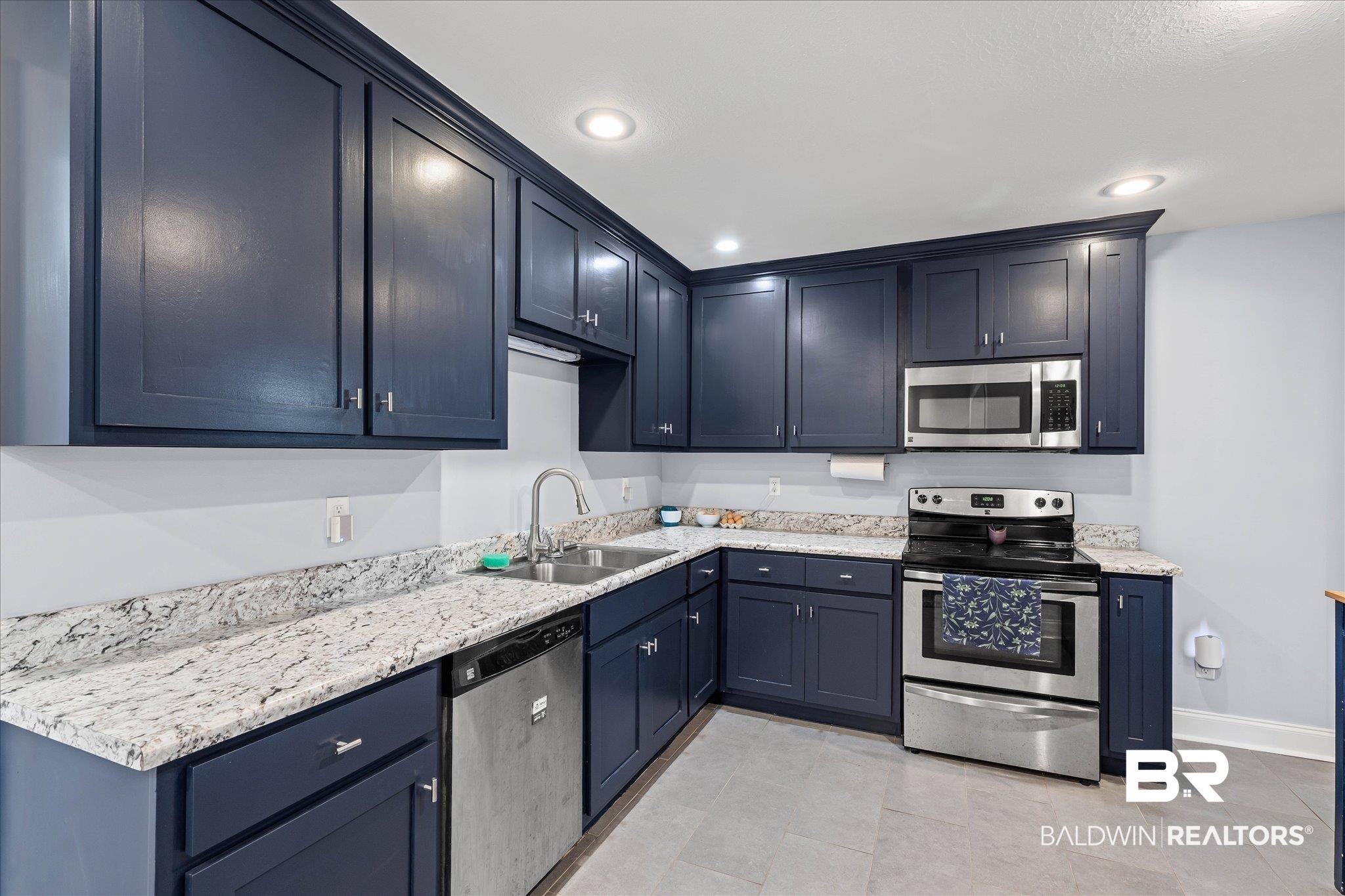 5609 Diane Court Mobile, AL 36618 - Photo 5 of 22 Kitchen with stainless steel appliances, light stone countertops, recessed lighting, light tile patterned flooring, and blue cabinets
