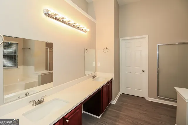 a bathroom with a double vanity sink a mirror and a shower