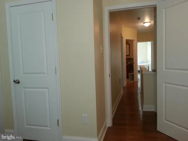 a view of a hallway with a wooden door