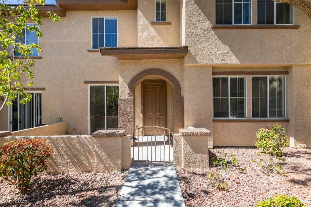 10220 Delray Beach Avenue, Unit 103 Las Vegas, NV 89129 - Photo 1 of 42 Property entrance featuring a gate, fence, and stucco siding