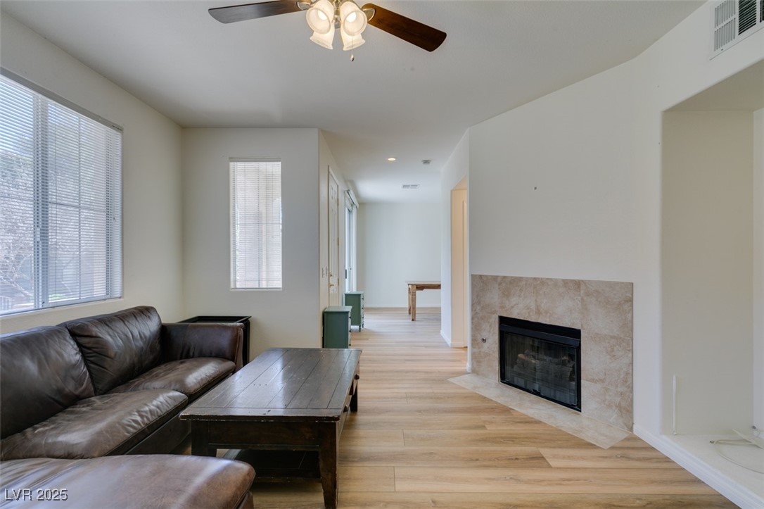 10220 Delray Beach Avenue, Unit 103 Las Vegas, NV 89129 - Photo 11 of 42 Living room featuring visible vents, a healthy amount of sunlight, light wood-style floors, and a ceiling fan