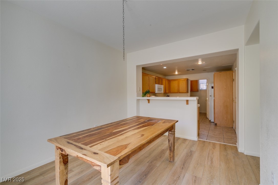 10220 Delray Beach Avenue, Unit 103 Las Vegas, NV 89129 - Photo 16 of 42 Dining room featuring baseboards and light wood-type flooring