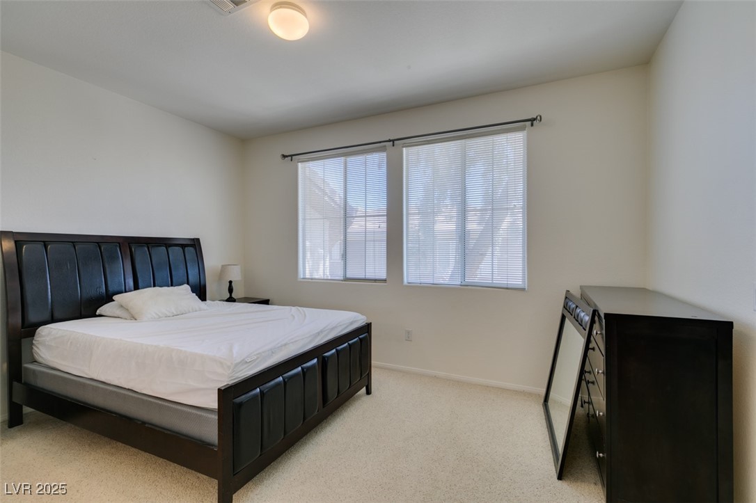 10220 Delray Beach Avenue, Unit 103 Las Vegas, NV 89129 - Photo 32 of 42 Bedroom featuring baseboards, visible vents, and light carpet
