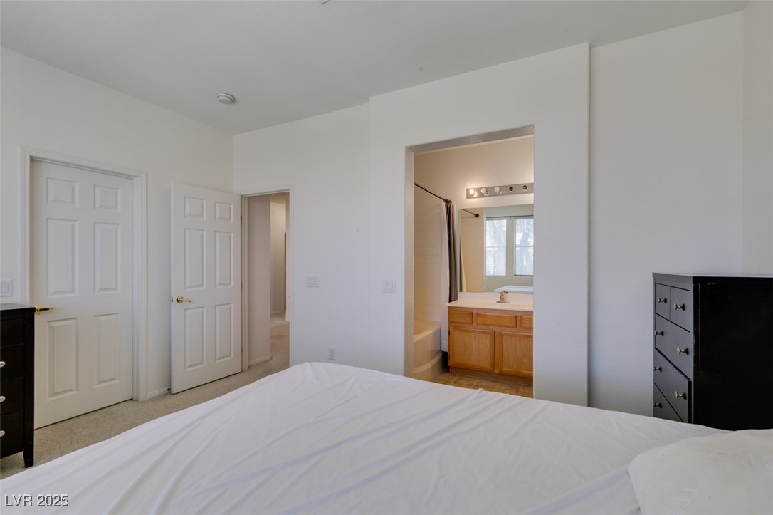 10220 Delray Beach Avenue, Unit 103 Las Vegas, NV 89129 - Photo 35 of 42 Bedroom featuring light carpet and connected bathroom