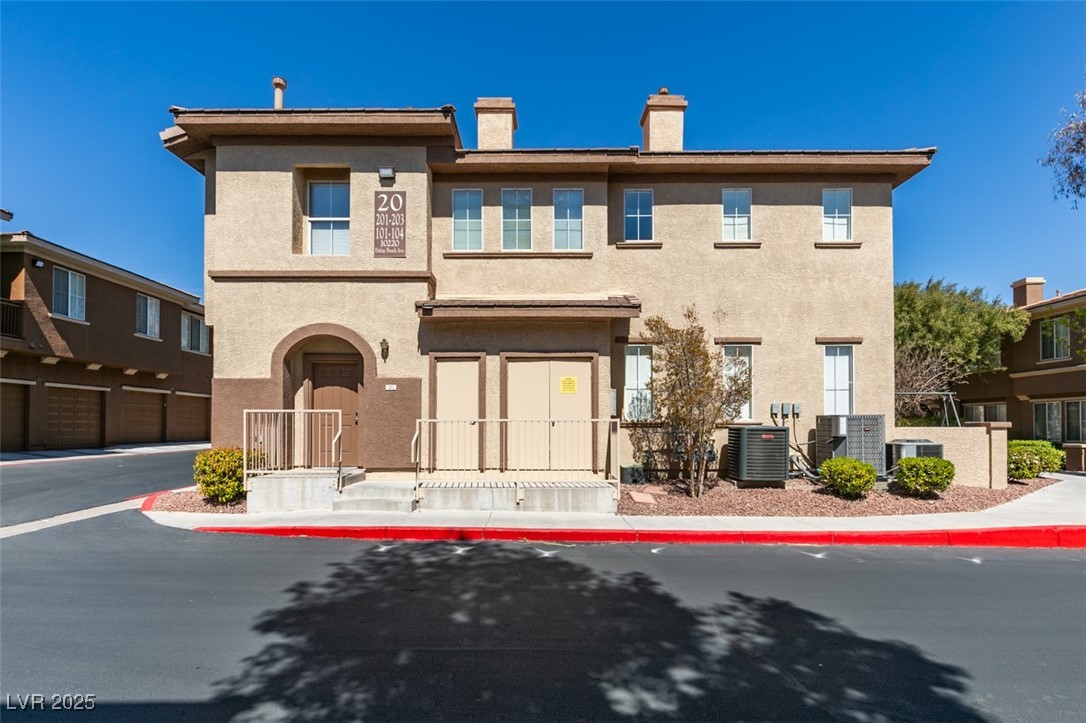 10220 Delray Beach Avenue, Unit 103 Las Vegas, NV 89129 - Photo 37 of 42 View of front of property featuring stucco siding, a chimney, and central air condition unit